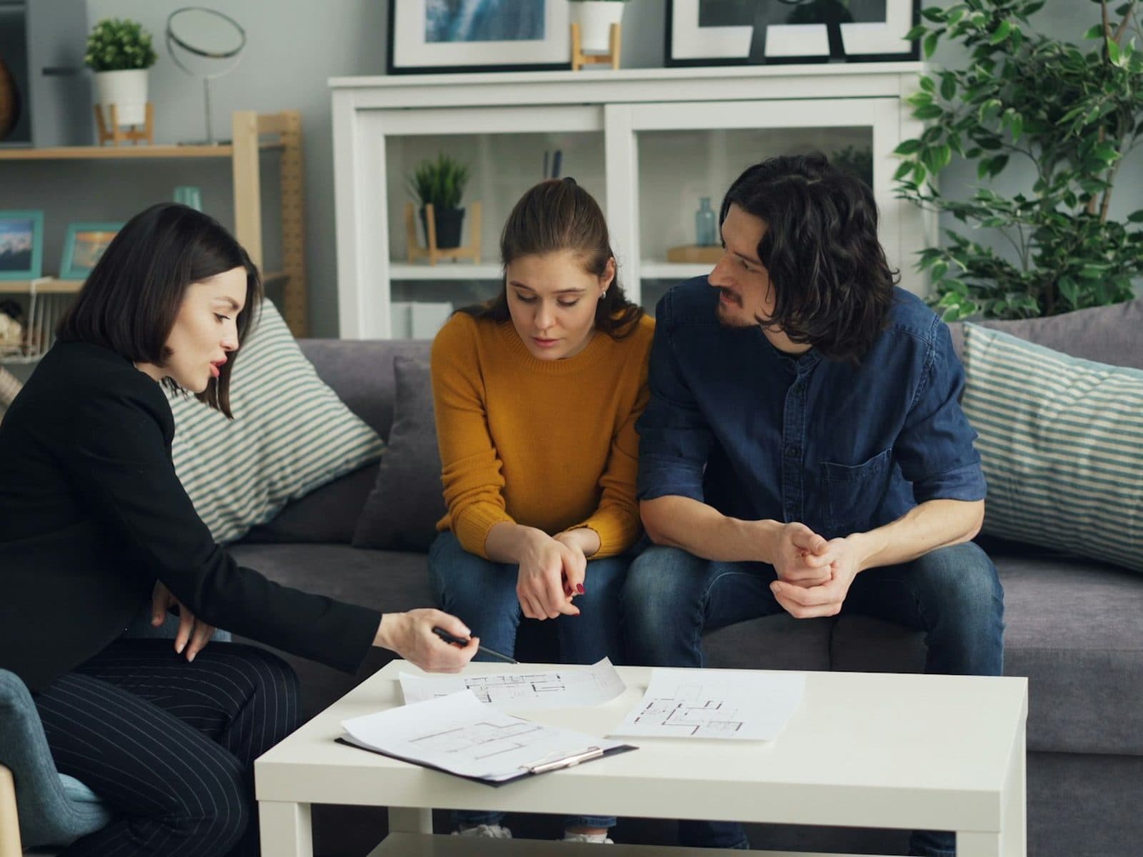 Conseillère révisant des documents avec un couple à la maison